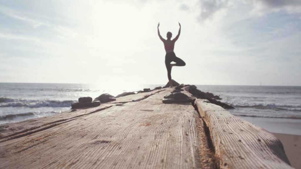 Healthy person doing yoga near ocean